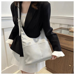 Sac hobo gris argenté avec bandoulière réglable et poches frontales symétriques