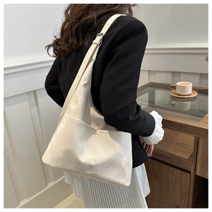 Détail du grand sac porté épaule blanc avec bandoulière large et boucle argentée