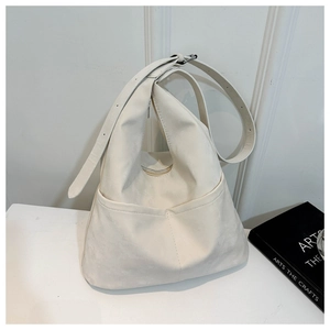 Détail du sac hobo blanc cassé montrant la texture suédée et la sangle réglable