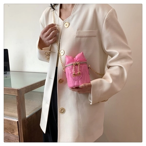Detailansicht der rosa gesteppten Mini-Beuteltasche mit Schleife und goldener Kette