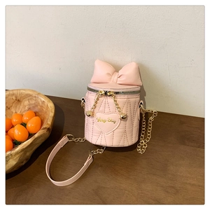 Detail der rosa Zylindertasche mit Steppmuster, Schleife und goldener Kette