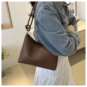 Détail d'un sac sous le bras en cuir PU tressé marron avec bandoulière à nœuds chic