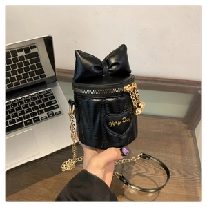 Detail der schwarzen Schleifen-Tasche mit V-Steppung und herzförmiger Stickerei