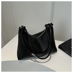 Detail shot of black woven leather tote bag with silver zipper on a minimalist stand
