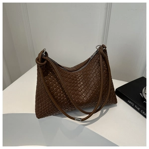 Detail of dark brown woven leather texture with silver metal ring and zipper closure
