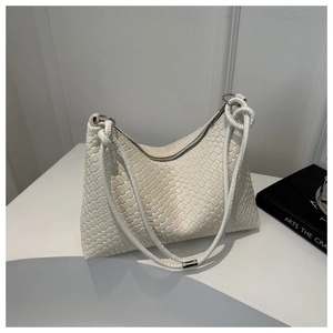 Detailed view of cream woven leather shoulder bag with knotted handle on white background