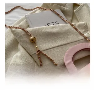 Detail of adjustable golden ball buckle and chain strap on quilted pink crossbody bag
