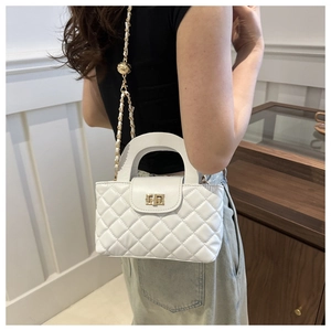 Détail du sac bandoulière blanc matelassé avec chaîne dorée et fermoir pivotant
