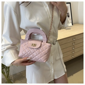 Détail du sac à main matelassé rose clair avec boucle dorée et bandoulière en chaîne