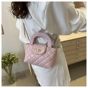 Détail du sac à main matelassé rose avec fermoir doré et bandoulière en chaîne