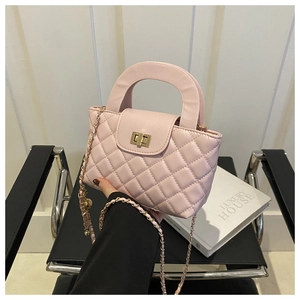 Détail du sac à bandoulière matelassé rose avec fermoir doré et bandoulière en chaîne