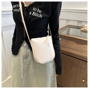 Close-up of white lychee pattern leather shoulder bag with smooth zipper and minimalist U-shape