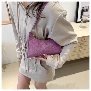 Dettaglio di una borsa sottobraccio con paillettes viola e finitura glitterata metallica