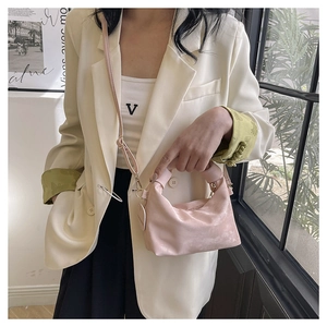 Detail of light pink pleated hobo bag showing adjustable shoulder strap and soft texture