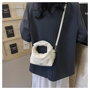 White pleated cloud crossbody bag shown from behind to display size and drape on a model