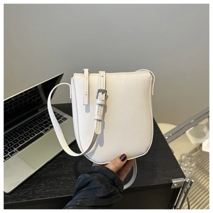 Close-up of white lychee texture leather handbag with adjustable silver metal buckle