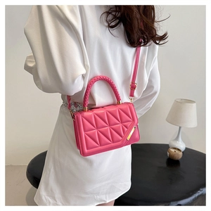 Détail du sac à main matelassé rose vif avec finitions dorées et poignée tressée chic