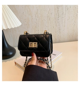 Detail of black quilted leather mini bag with gold chain strap and turn-lock closure