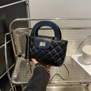 Sac à main noir matelassé avec bandoulière chaîne dorée et breloque métallique