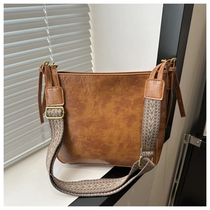 Détail du sac cabas marron vintage avec texture grainée et bandoulière tissée chic