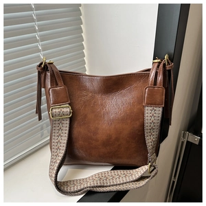 Détail du sac cabas marron caramel avec large bandoulière à motifs vintage et texture PU