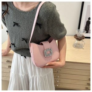 Vue détaillée du sac à bandoulière rose avec boucle en cristal en situation réelle