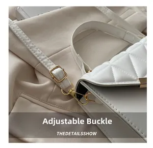 Detailed macro view of white quilted faux leather texture with adjustable gold hardware buckles