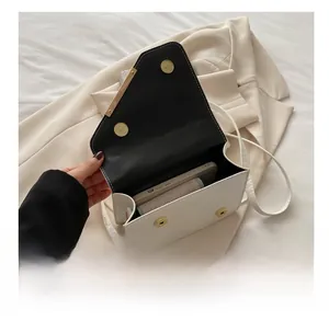 Internal view of minimalist white quilted handbag showing magnetic closure and black lining