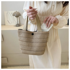 Détail du sac cabas tissé main avec poignées en toile et fermeture à bouton-pression