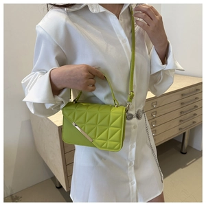 Close-up of a bright green quilted leather handbag with silver metallic details and handle