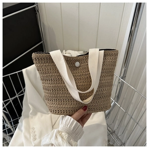 Gros plan du sac cabas tissé beige avec texture en corde fine et fermeture à bouton blanc