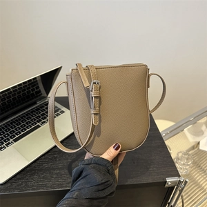 Minimalist taupe leather saddle bag with adjustable strap for casual daily use