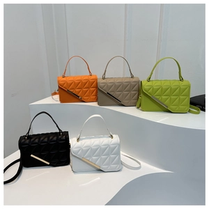 Five minimalist leather handbags in diverse colors displayed on a modern white pedestal