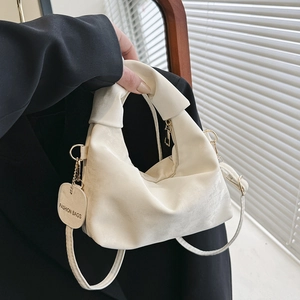 Chic beige pleated handbag with knotted handle and shoulder strap in a minimalist style