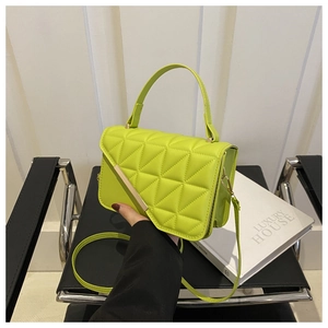 Detail of neon green quilted handbag with geometric pattern and gold metal buckle