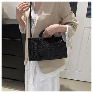 Detail view of black crocodile pattern PU leather shoulder bag with circular handle