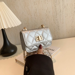 Mini silver quilted chain bag with gold twist lock and metallic finish crossbody style