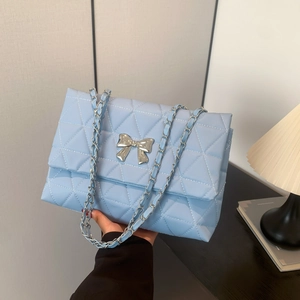 Light blue quilted shoulder bag with silver bow accent and classic metal chain strap