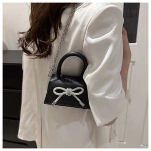 Vue détaillée du mini sac noir en cuir grainé avec un nœud en strass argentés brillants