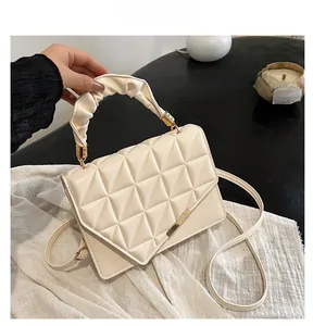 Détail du sac matelassé crème avec fermoir doré et poignée élégante plissée