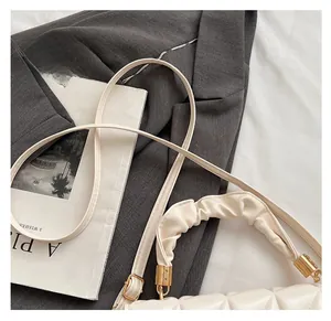 Détail du sac matelassé crème avec poignée nuage froncée et fermoirs dorés élégants