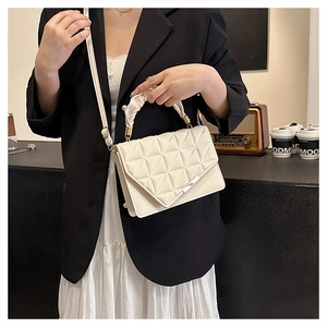 Détail du sac à main matelassé crème avec poignée plissée et garnitures dorées