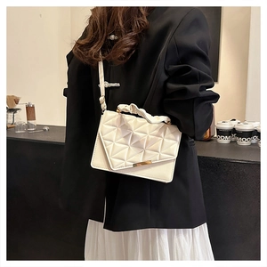 Sac bandoulière beige chic avec matelassage géométrique et poignée froncée sur un modèle