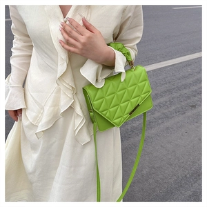 Sac à main matelassé vert vif avec poignée froncée et détails dorés sur modèle