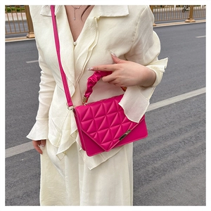 Détail du sac matelassé fuchsia avec texture 3D triangulaire et poignée nuage froncée