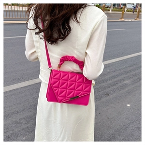 Détail de la poignée plissée rose et texture matelassée géométrique du sac à main