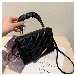 Détail du sac à main noir matelassé avec texture en V et poignée plissée style nuage