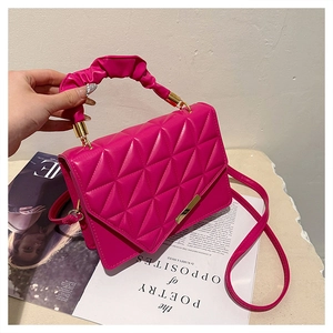 Détail du sac matelassé rose vif avec ferrures dorées et poignée nuage froncée