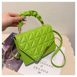 Détail du sac à main en cuir matelassé vert avec poignée froncée et fermoir doré chic