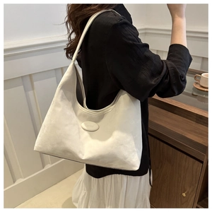 Detail of a white microfiber hobo bag showing the suede texture and logo on the shoulder strap